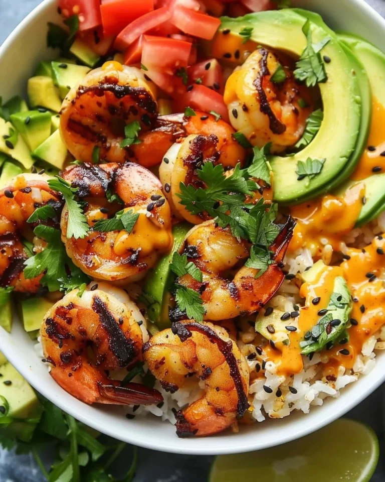 Healthy grilled shrimp served in an avocado bowl with fresh vegetables